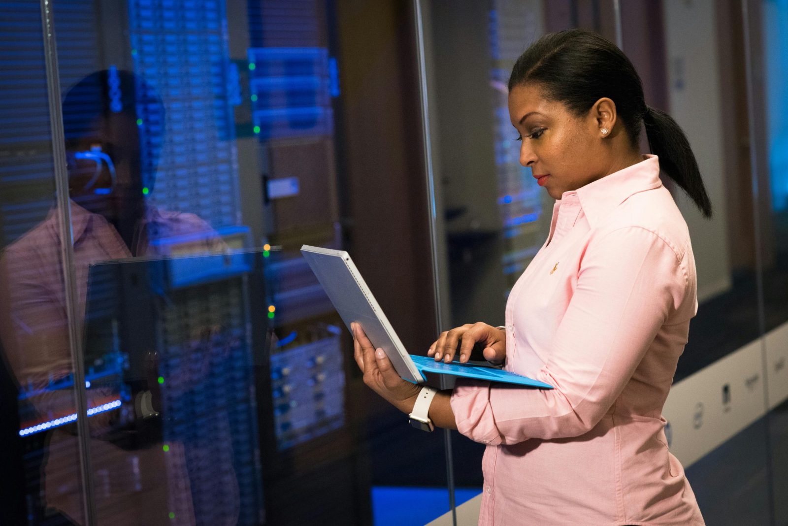 Un ingénieur logiciel concentré, travaillant sur un ordinateur portable dans une salle de serveurs, témoigne de son dévouement à la technologie.