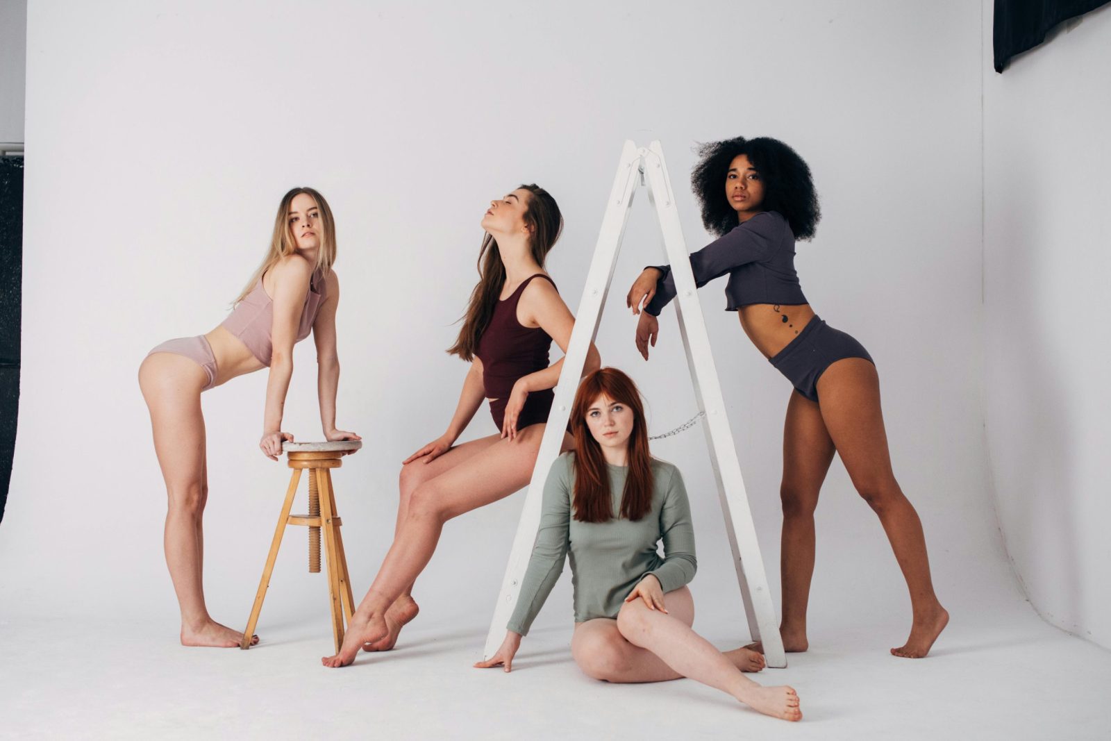 Un groupe de femmes aux profils variés posant en lingerie tendance lors d'une séance photo en studio.